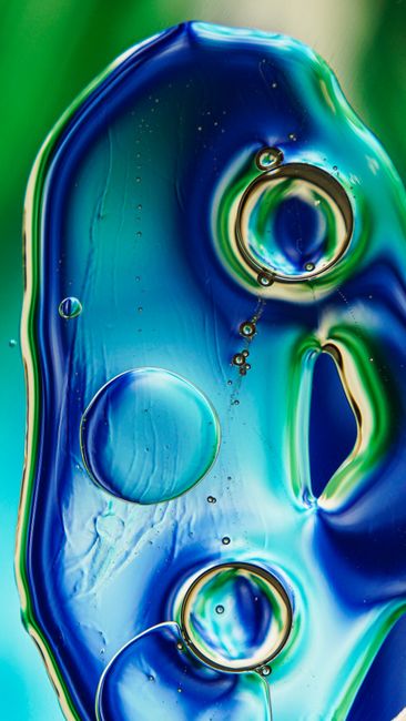 Fotomural Imagen abstracta y cautivadora de un líquido azul y verde con burbujas que crean un patrón dinámico.