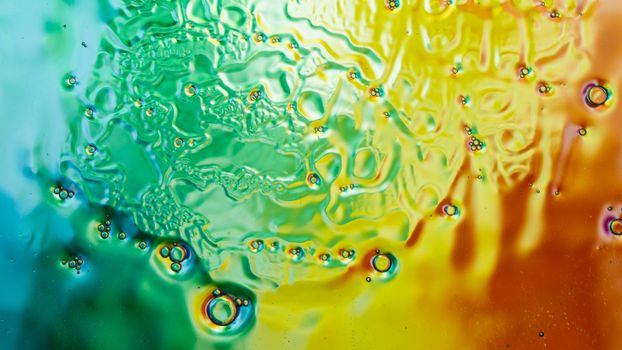 Vibrant abstract liquid bubbles in yellow-orange and green-blue hues.