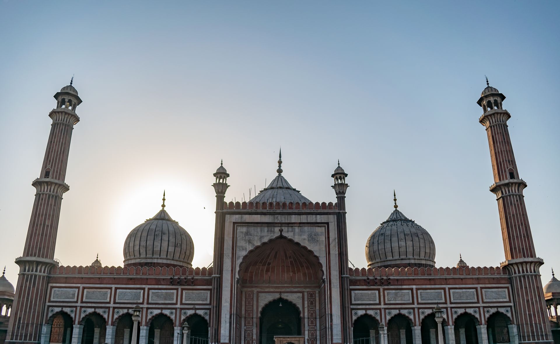 Stunning view of Jama Masjid in New Delhi silhouetted against the sun.