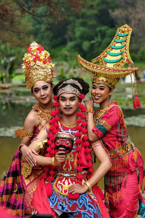 Free Three people in vibrant traditional Indonesian dance costumes pose outdoors in Jawa Barat. Stock Photo