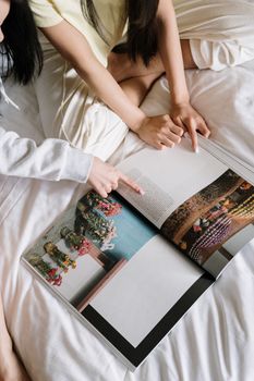 两个女人舒适地躺在床上，一起翻阅一本充满活力的相册