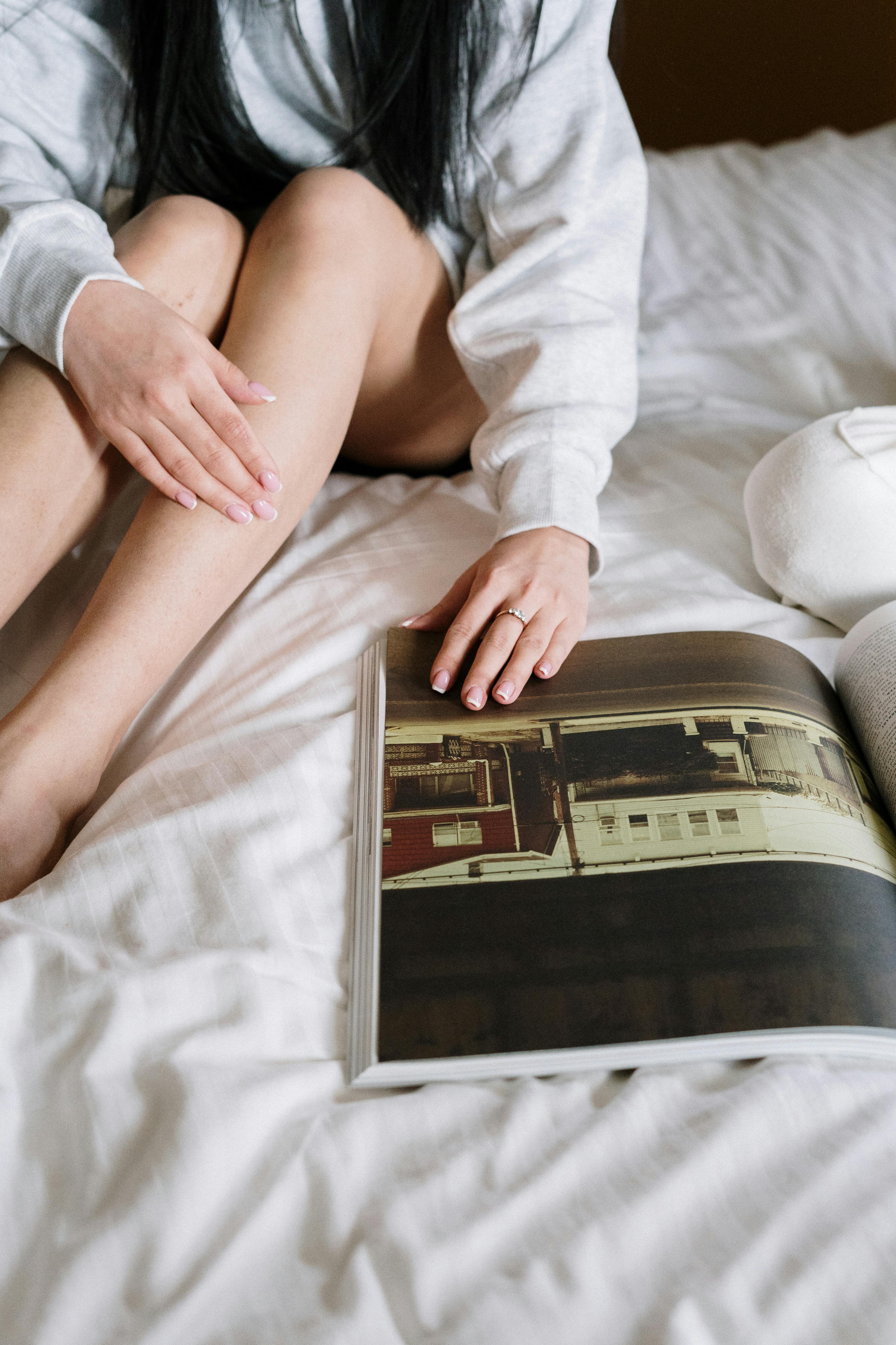 person in white dress shirt sitting on bed