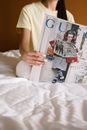 Woman in White T-shirt Holding White and Red Book