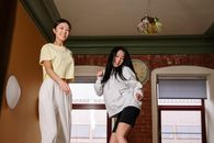 两个朋友在温馨舒适的公寓里一起欢乐地跳舞