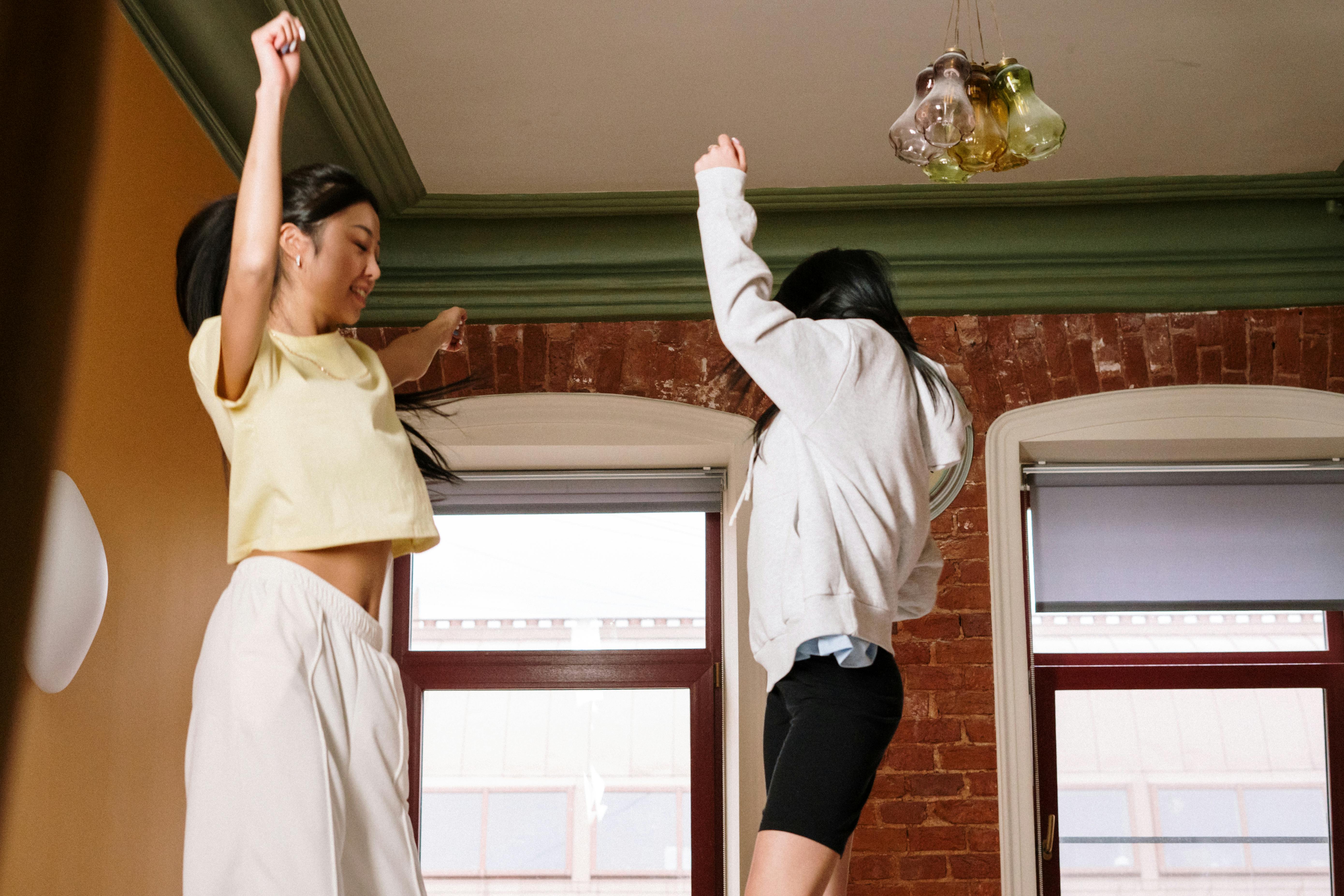 woman in white long sleeve shirt and black shorts standing near window