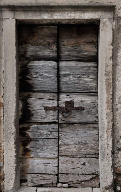 Free A weathered wooden door with rustic charm in Malcesine, Italy's historic center. Stock Photo