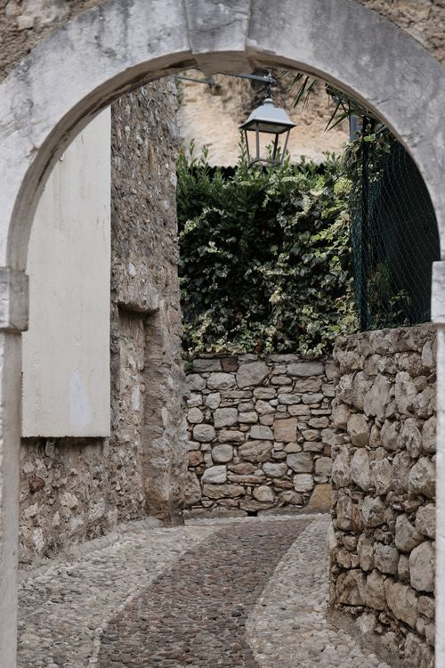 Free Explore the rustic charm of Malcesine through its historic stone alleyways and archways. Stock Photo