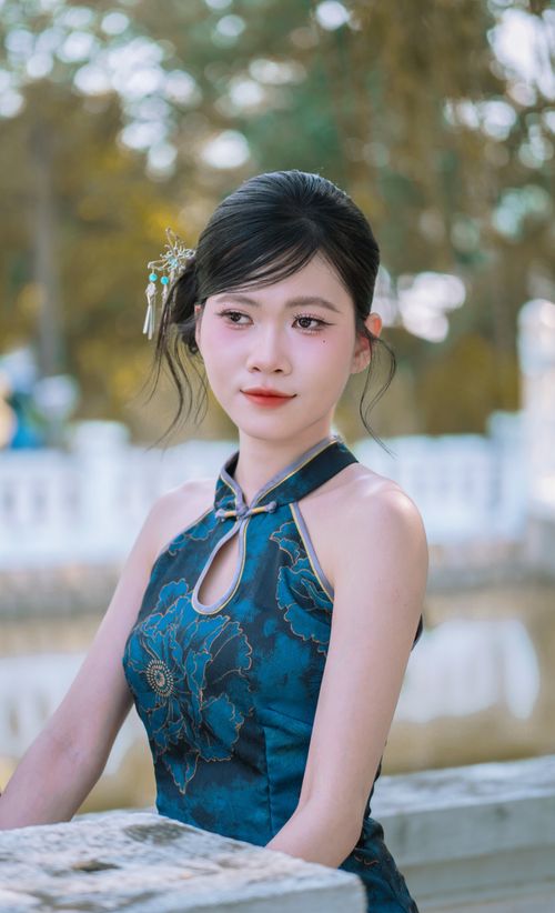 Free Young woman in blue traditional dress poses elegantly outdoors. Stock Photo
