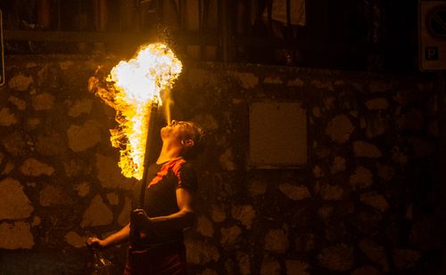 Free Dramatic night shot of a fire breather engaging in an exciting performance, creating an awe-inspiring flame. Stock Photo