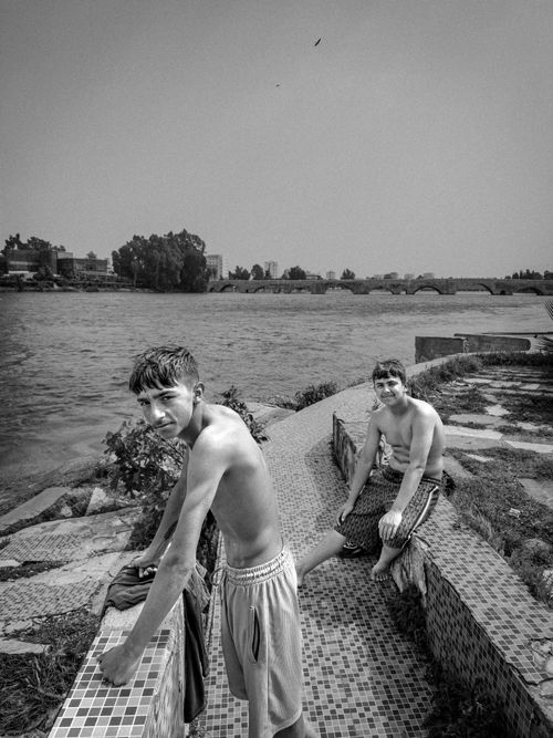 Free Two teenage boys enjoying a sunny day by the river in black and white. Stock Photo