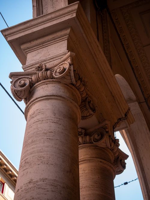 Free Close-up of Greek-style architectural columns showcasing intricate designs under a blue sky. Stock Photo