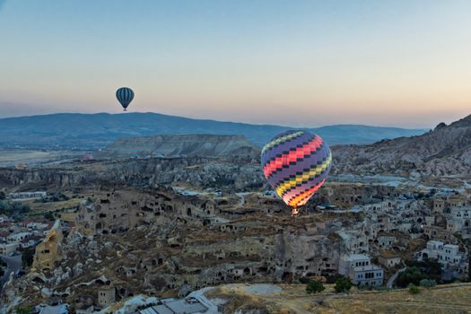 Breathtaking scene of colorful hot air balloons soaring above Cappadocia's unique landscape at dawn.
