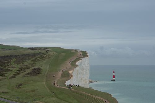 Free A breathtaking vista of Seven Sisters Cliffs with a lighthouse by the sea. Stock Photo