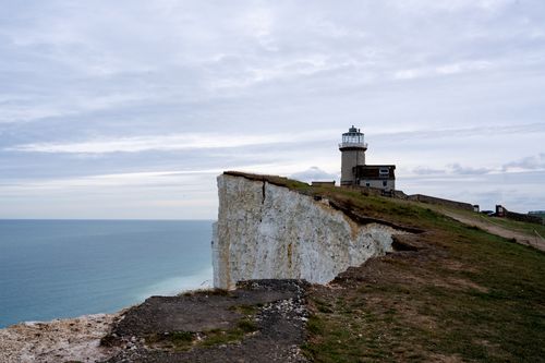 Free Scenic view of Beachy Head lighthouse on white chalk cliffs overlooking the sea. Stock Photo