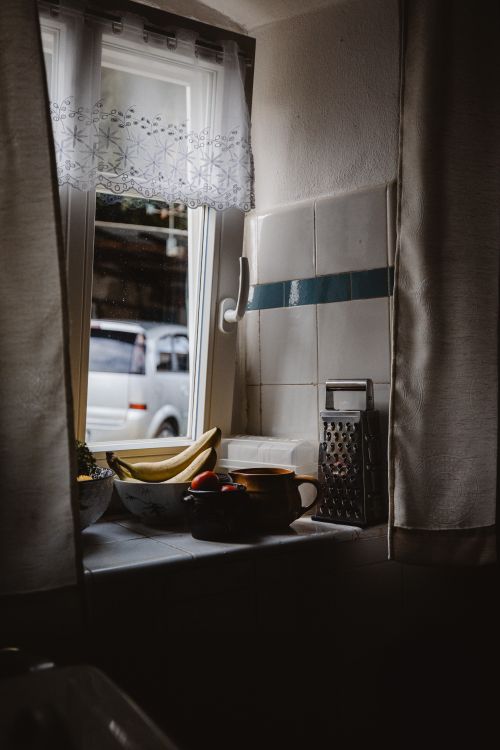 Free A serene kitchen window scene with bananas, coffee mug, and cheese grater in Zittau, Germany. Stock Photo