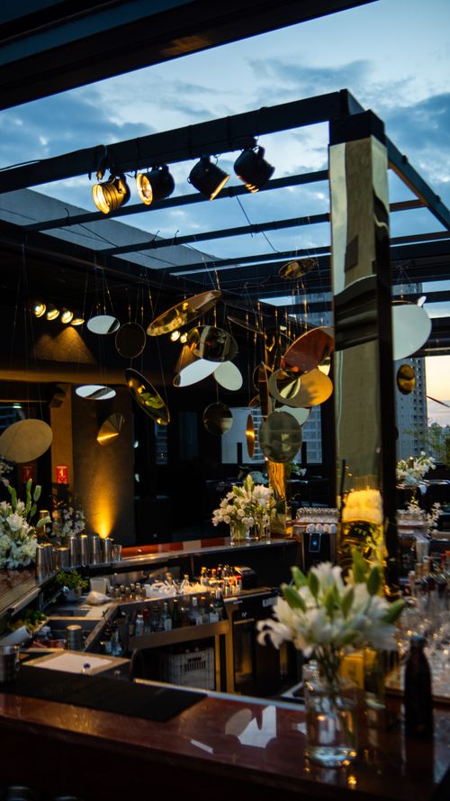 Free Elegant rooftop bar at twilight with modern lighting and decor, offering a sophisticated urban ambiance. Stock Photo