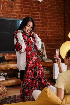 两个朋友在室内试穿衣服，享受休闲的一天