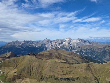 A breathtaking aerial view of the Dolomites with clear blue skies and lush terrain.