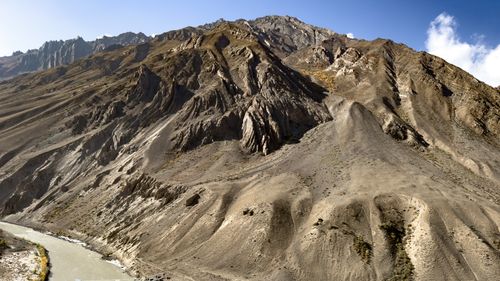 Free Expansive mountain view with river, showcasing rugged slopes under a clear blue sky. Stock Photo