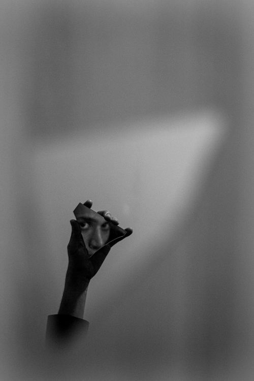 Free A black and white image showcasing an eye in a broken mirror piece, held by a hand. Stock Photo