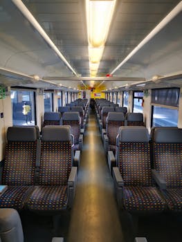 An empty modern train interior with blue seats and bright lighting, perfect for travel concept.