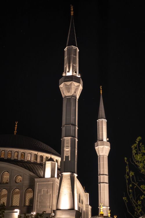 Free A night view of Kocatepe Mosque minarets gracefully lit against the dark sky in Ankara, Türkiye. Stock Photo