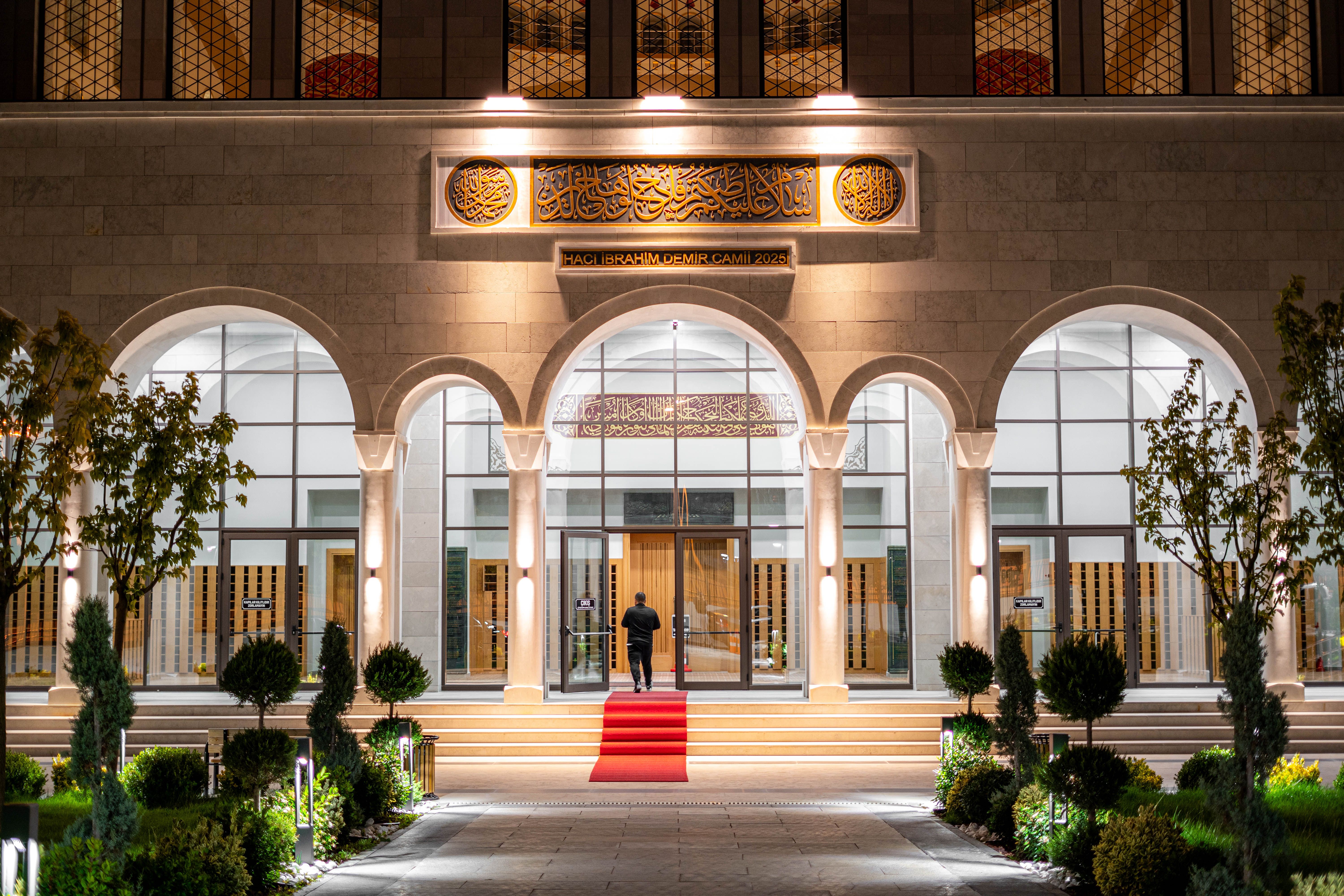 Elegant exterior of a mosque in Ankara with illuminated architecture and red carpet entrance.