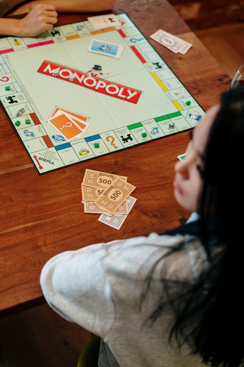 Free Monopoly Board Game on Brown Wooden Table Top  Stock Photo