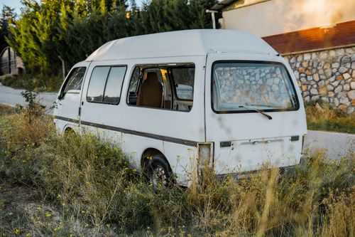 Free A vintage white van sits abandoned amidst overgrown grass in Gölbaşı, Ankara. Stock Photo