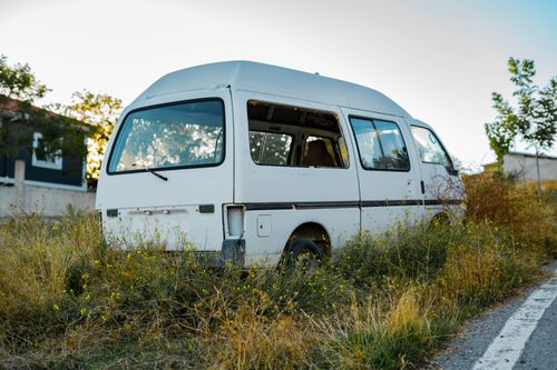 Free A neglected white van sits abandoned in an overgrown field in Gölbaşı, Ankara, Türkiye. Stock Photo