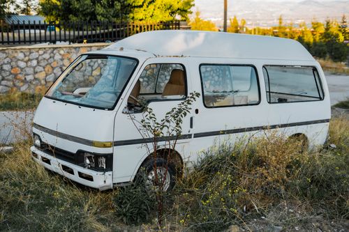 Free An abandoned white van parked in an overgrown field in Gölbaşı, Ankara, Türkiye. Stock Photo