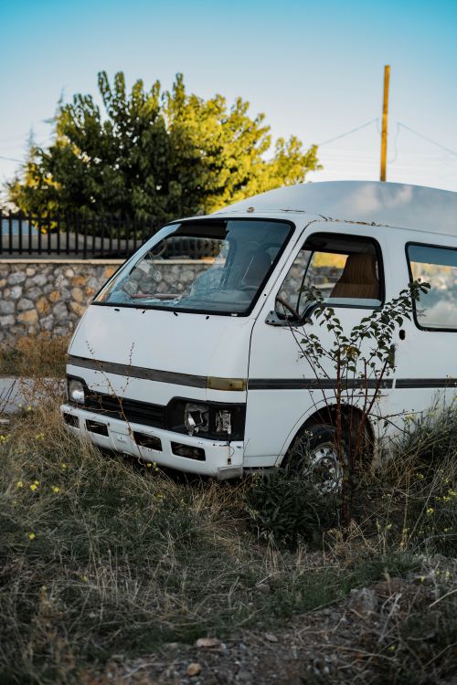 Free A white van sits abandoned in a grassy field in Gölbaşı, Ankara, Türkiye, conveying a sense of decay. Stock Photo