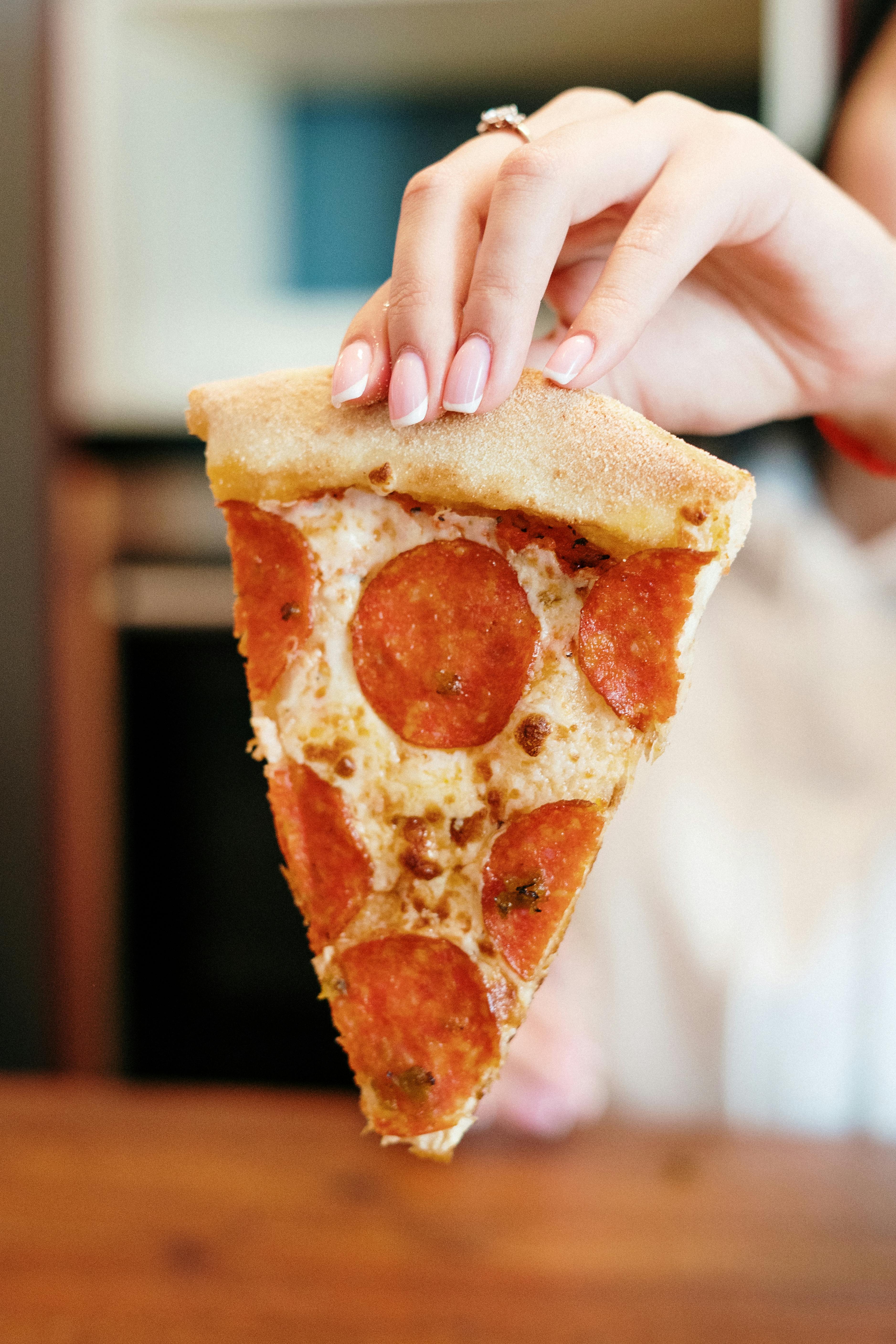 person holding sliced of pizza
