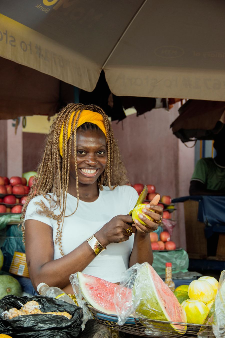 Une commerçante souriante prépare des fruits sur son étal