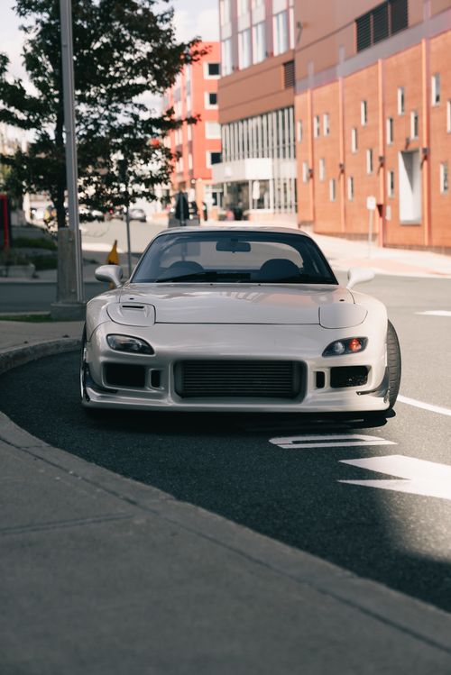 Free A modern sports car parked on a city street under daylight. Stock Photo