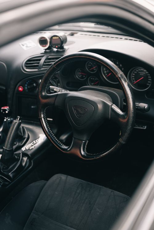 Free Elegant steering wheel and dashboard of a high-performance sports car showcasing advanced design features. Stock Photo