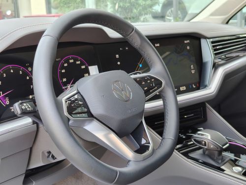 Free Sleek car interior showing a modern steering wheel and digital dashboard displays. Stock Photo