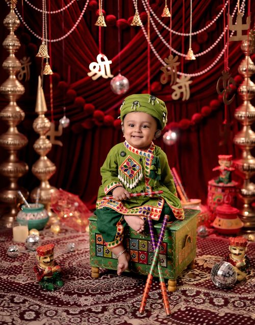 Free Adorable baby dressed in vibrant traditional Indian clothing, surrounded by festive decorations. Stock Photo
