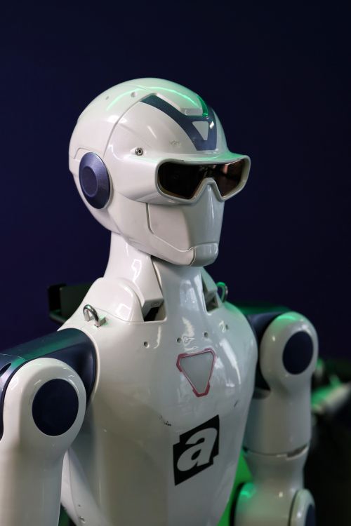 Free A sleek, modern robot showcased at a technology expo, illustrating AI advancement. Stock Photo