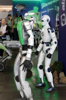 Two humanoid robots displayed at a high-tech exhibition, showcasing innovation.