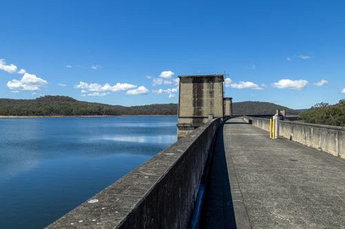 Free Peaceful view of Cordeaux Dam in New South Wales with clear blue skies and tranquil waters. Stock Photo