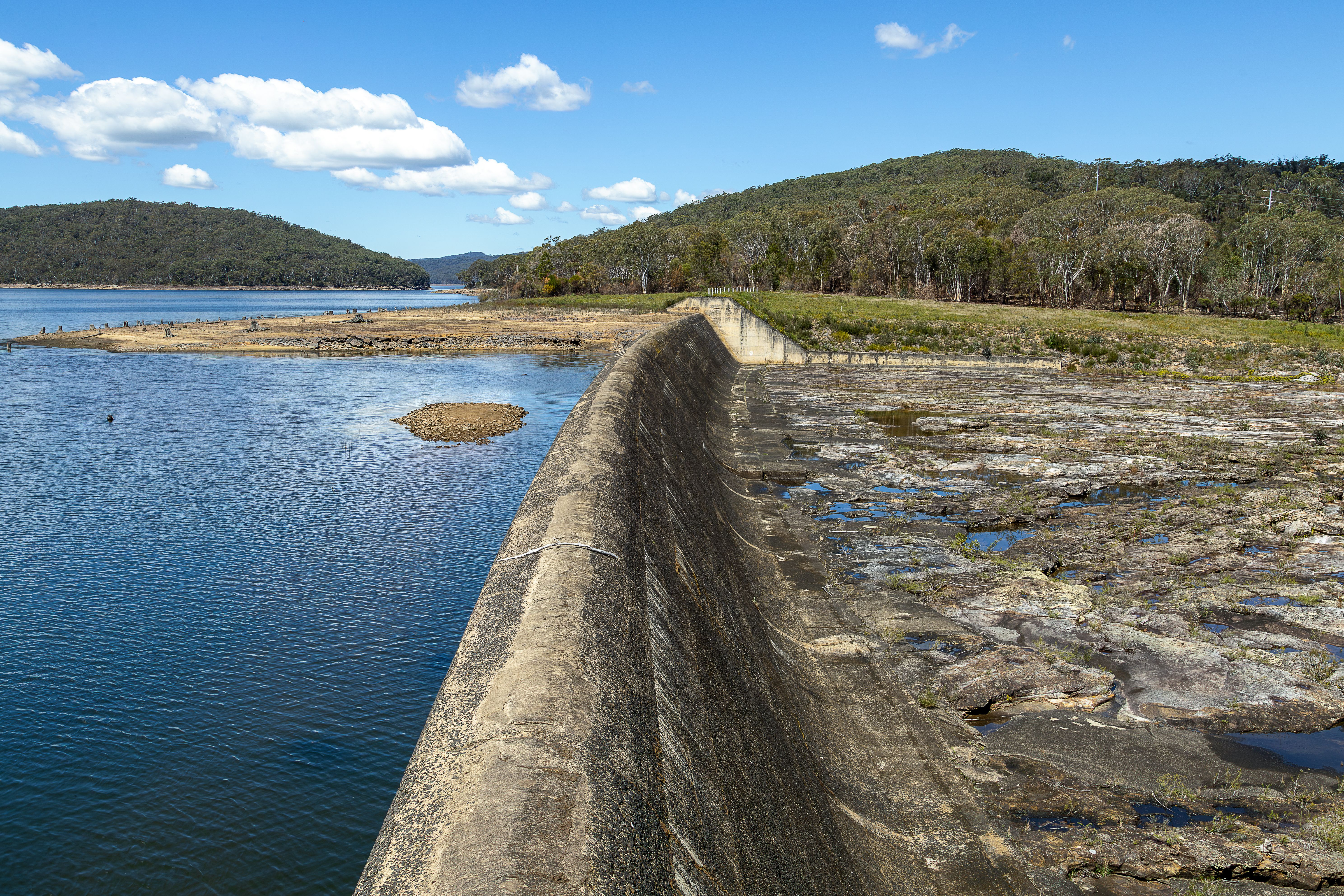 Cordeaux Dam and surrounding landscape in New South Wales, Australia, under a clear blue sky.