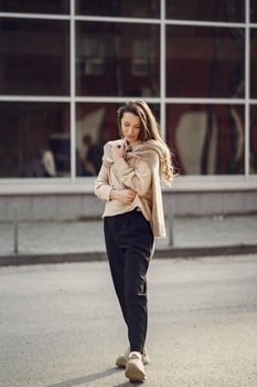 Full length of young thoughtful female with long hair in casual clothes looking away while standing on street