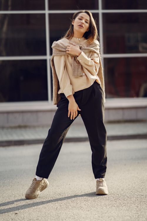 Free Full length of young female with long hair in casual clothes looking at camera while standing on street Stock Photo