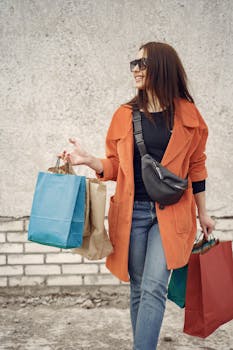 Smiling woman enjoying shopping with bags in urban setting.