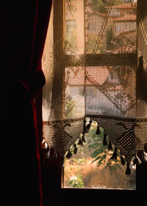 Free Sunlight filters through a decorative crochet curtain, casting intricate shadows. Stock Photo
