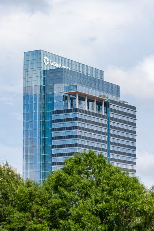 Free Contemporary glass office building with green foliage in foreground in Richmond, VA. Stock Photo