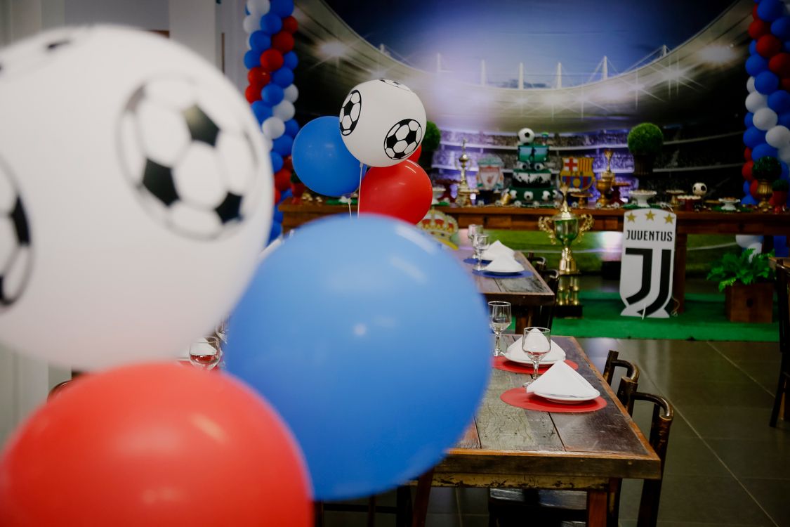 Soccer-themed birthday party setup with colorful balloons and sport-themed table decorations