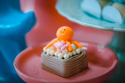 Adorable clay octopus figurine on a colorful decorative plate, perfect for kids' room decor.