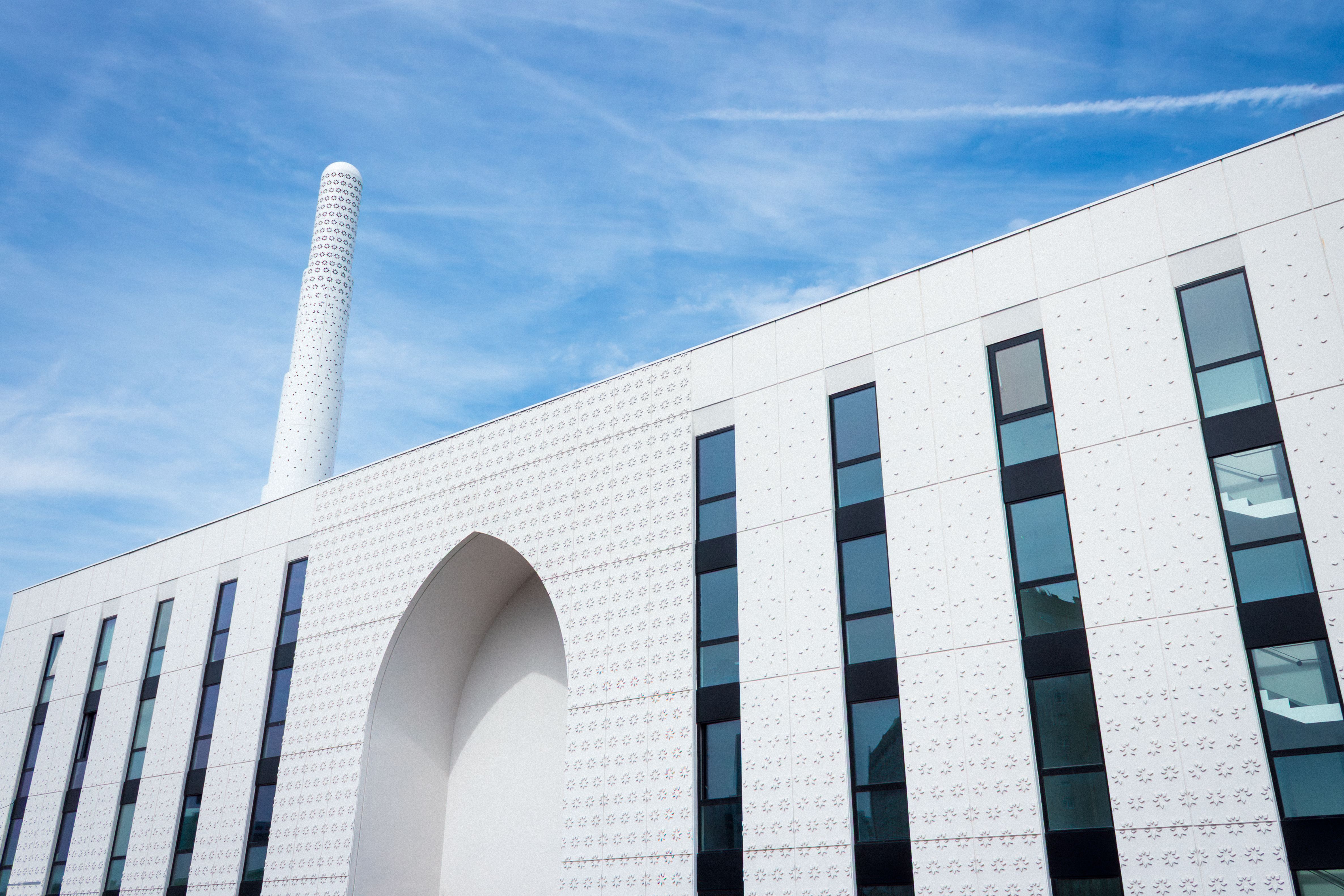 Modern mosque with a striking minaret in Paris, featuring contemporary Islamic design.
